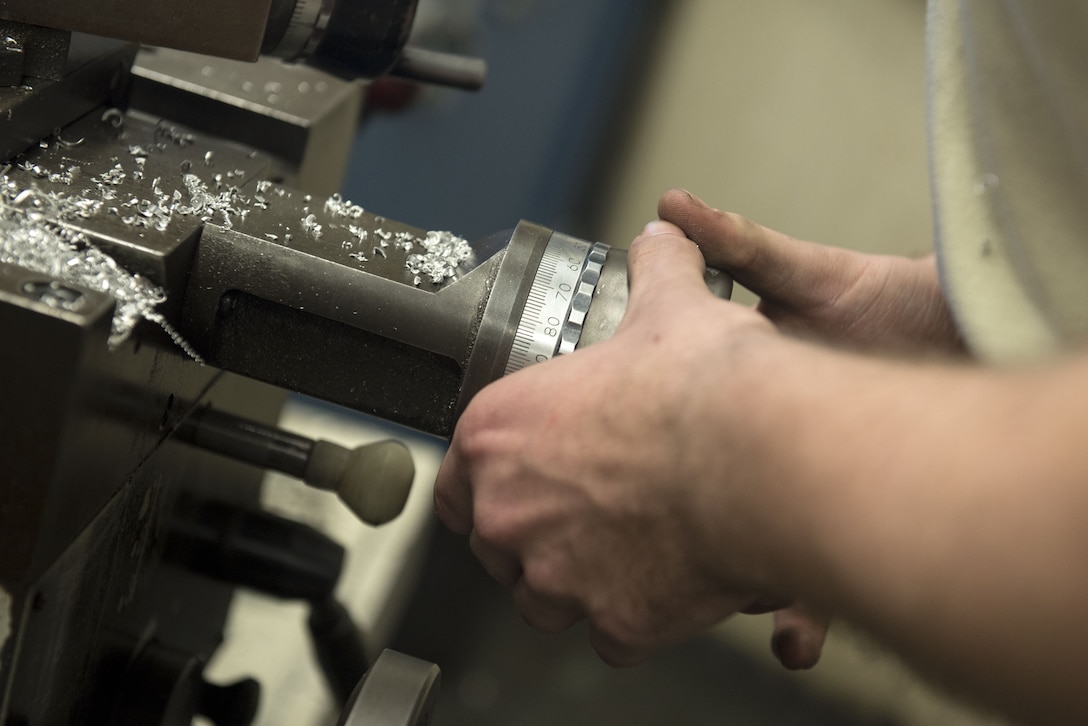 U.S. Air Force Airman 1st Class Peter Lockett, 20th Equipment Maintenance Squadron metals technology technician, adjusts the settings on a lathe to shave down a piece of metal at Shaw Air Force Base, S.C., Jan. 30, 2018.