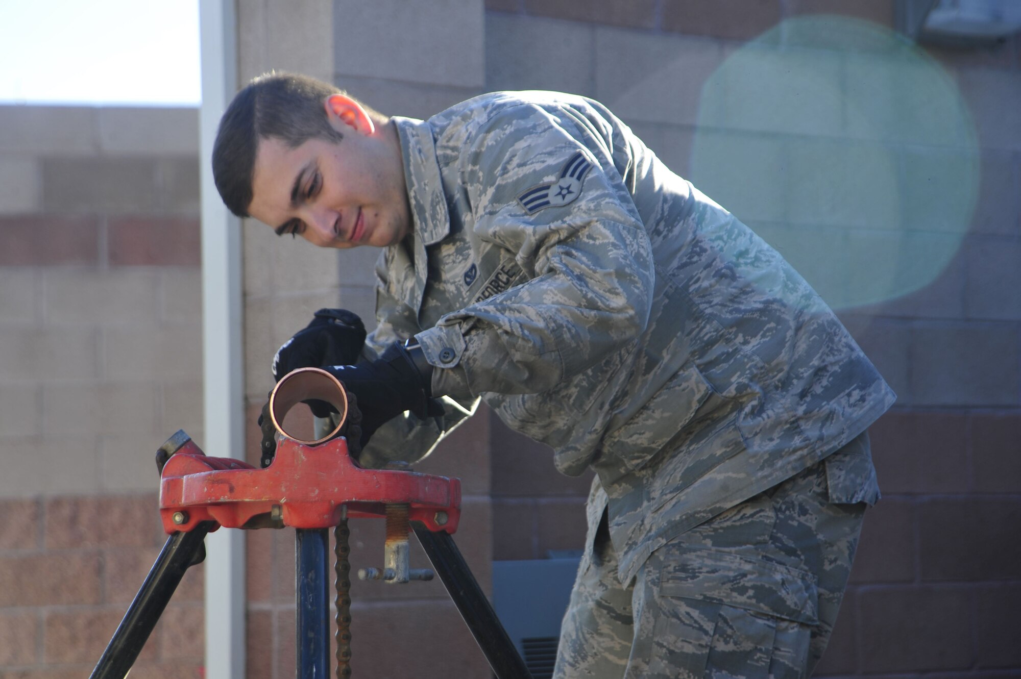 U.S. Air Force Senior Airman Andres Macias, 355th Civil Engineer Squadron HVAC journeyman, reams a copper pipe for a chiller at Davis-Monthan Air Force Base, Ariz., Jan. 31, 2018.