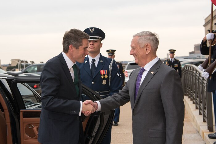 Defense Secretary James N. Mattis shakes hands with British Defense Secretary Gavin Williamson as Williamson exits a car.