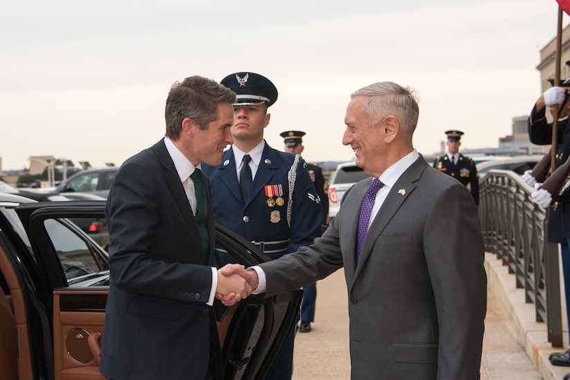 Defense Secretary James N. Mattis shakes hands with British Defense Secretary Gavin Williamson as Williamson exits a car.