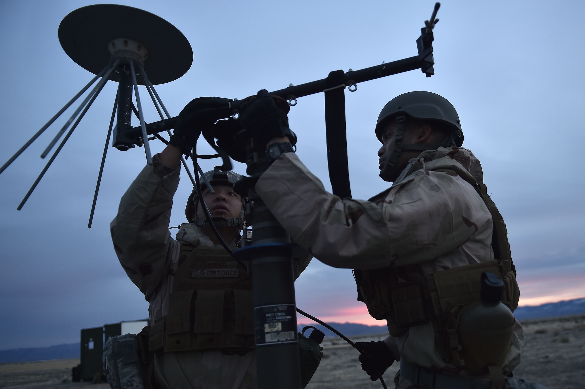 Senior Airmen Yuhao Huang and Zyrus Medina, 821st Contingency Response Support Squadron frequency technicians, set-up a line of sight antenna while deployed to Amedee Army Airfield, Calif., as part of a week-long readiness exercise, Jan. 31, 2018.  The exercise evaluated the Airmen’s readiness and ability to execute and sustain rapid global mobility around the world. (U.S. Air Force photo by Tech. Sgt. Liliana Moreno/Released)