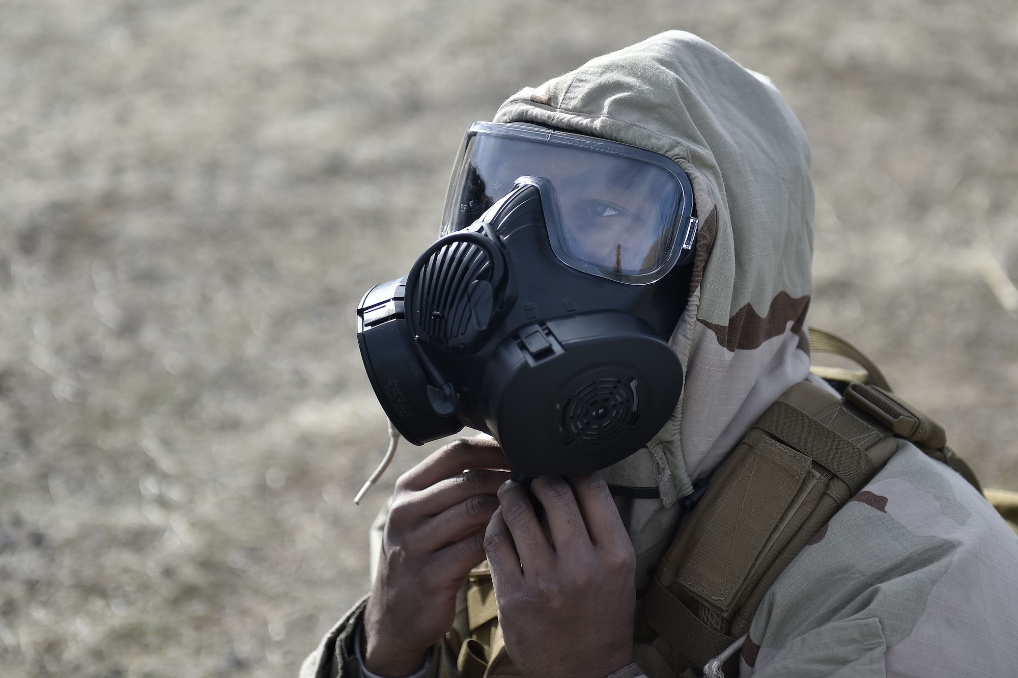 Senior Airman Devante Jenkins, 821st Contingency Response Squadron aerial porter, dons Mission Oriented Protective Posture gear during a simulated attack while deployed to Amedee Army Airfield, Calif., as part of a week-long readiness exercise, Feb. 1, 2018.  The exercise evaluated the Airmen’s readiness and ability to execute and sustain rapid global mobility around the world. (U.S. Air Force photo by Tech. Sgt. Liliana Moreno/Released)