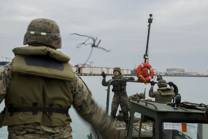 Lance Cpl. Andrew Hollom (left), a combat engineer with Bridge Company, 9th Engineer Support Battalion, Combat Logistics Regiment 35, throws a rope to Lance Cpl. Alex Hisey, also a combat engineer with Bridge Co., to secure the Bridge Erection Boat to an Improved Ribbon Bridge (IRB) bay at Naha Military Port, Okinawa, Japan Jan. 31, 2018. Bridge Co. conducted training with IRBs to train new Marines and to show the capabilities of the newly-formed company. Hollom is a native of Poplar, Montana. Hisey is a native of Toledo, Ohio. (U.S. Marine Corps photo by Pfc. Jamin M. Powell)