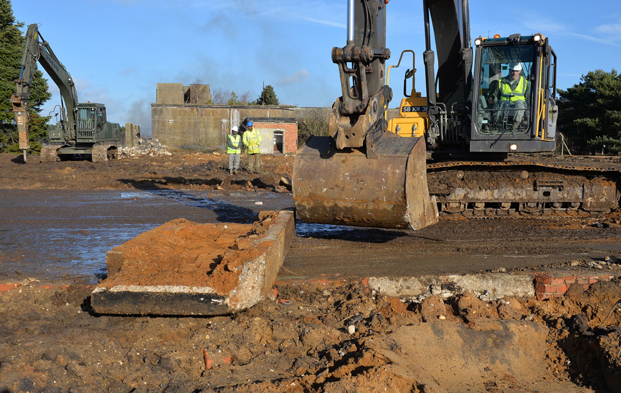 U.S. Air Force Staff Sgt. William Baynard, 100th Civil Engineer Squadron pavements and equipment supervisor, breaks up a concrete apron using a British Army excavator at Rock Barracks, Woodbridge, England, Jan. 25, 2018. The excavator followed the jack hammer – used to initially break up the concrete – and ripped up chunks of it to be hauled away. Using the equipment gave the 100th CES Airmen valuable “stick time,” which they are not easily able to get as there are no excavators at RAF Mildenhall. (U.S. Air Force photo by Karen Abeyasekere)