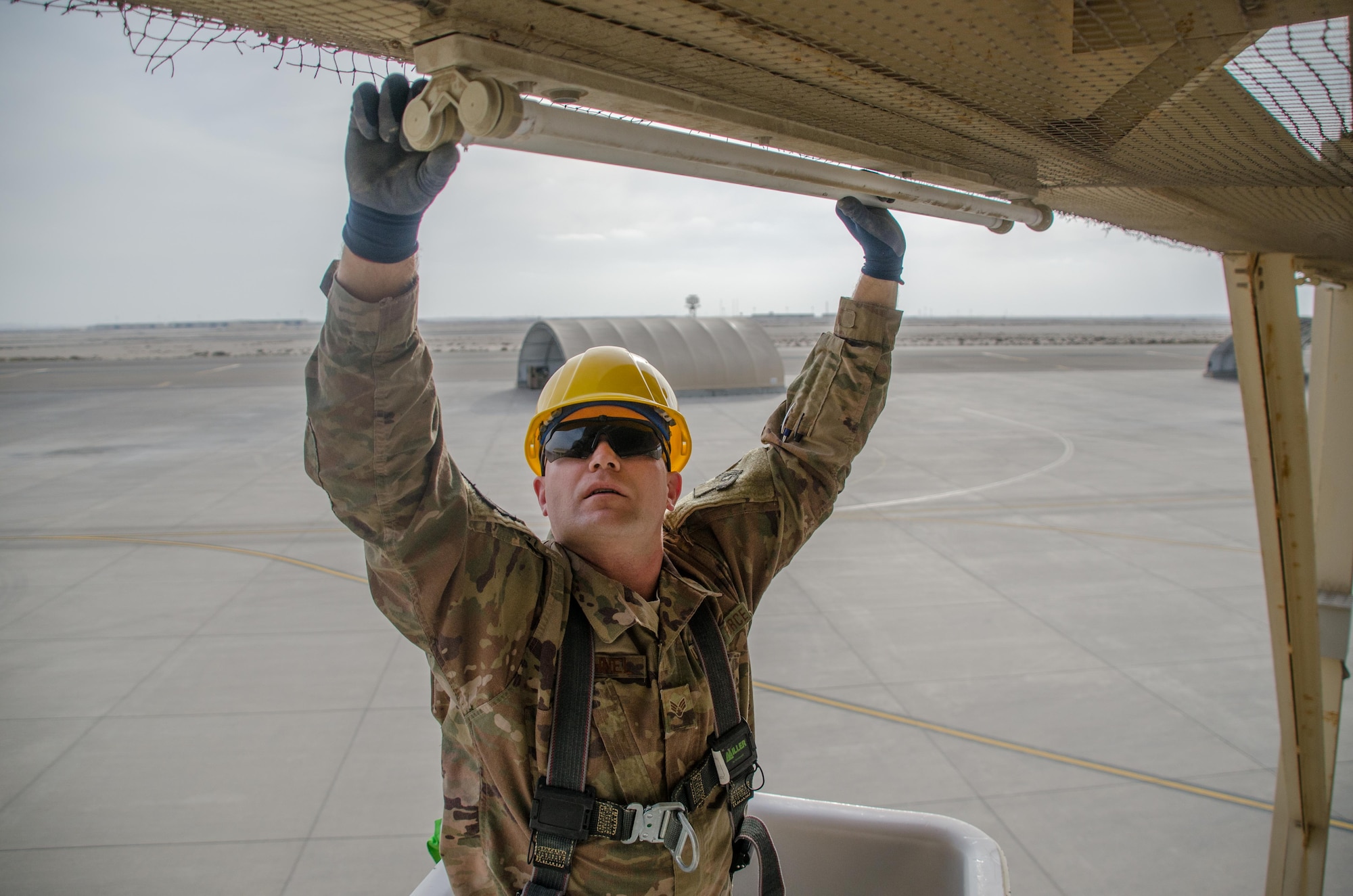 U.S. Air Force Senior Airman Robert Haehnel, 380th Expeditionary Civil Engineer Squadron electrical specialist, installs a new energy efficient light-emitting diodes (LED) light bulb on Al Dhafra Air Base, United Arab Emirates, Jan. 29, 2018. The 380th ECES electrical section has replaced more than 2,000 incandescent light bulbs on ADAB. (U.S. Air National Guard photo by Staff Sgt. Colton Elliott)