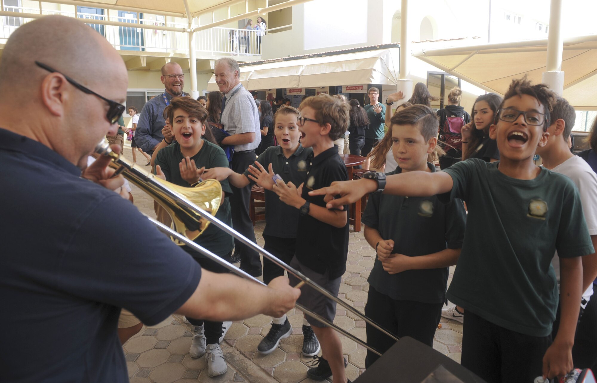 U.S. Air Force Master Sgt. Jeremy Grant, Air Forces Central Command band trombonist, plays a popular song after a concert at a school in the United Arab Emirates, Jan. 28, 2018. Grant played a song made popular by online personalities known as trombone dad and oven boy. (U.S. Air Force photo by Tech. Sgt. Anthony Nelson Jr.)