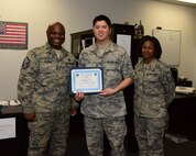 Staff Sgt. Richard Lee, 14th Operations Support Squadron Quality Assurance Non-Commissioned Officer in charge for Aircrew Flight Equipment, receives the Columbus Air Force Base Top 3 Spotlight from Master Sgt. Demetri Harper, Top Three Vice President and Master Sgt. Carmina Beedle, 14th OSS AFE Superintendent, Jan. 24, 2018, on Columbus Air Force Base, Mississippi. He is also the lead Aircrew Continuation Training instructor for roughly 684 instructor, student, and international pilots. Staff Sgt. Lee was hand-selected by the current operations flight commander to conduct training for the Vice Chief of Staff Headquarters of the United States Air Force, for his T-6 flight. (U.S. Air Force photo by Elizabeth Owens)