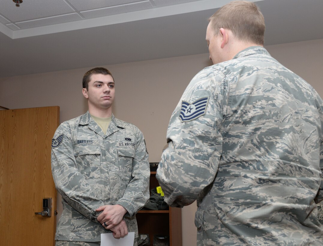 Staff Sgt. Devin Bartlett, a B-1 Bomber crew chief assigned to the 28th Aircraft Maintenance Squadron, receives his 7-level career development course results from Tech. Sgt. Jed Abbott, the base education and training manager assigned to the 28th Force Support Squadron, inside the Rushmore Center at Ellsworth Air Force Base, S.D., Jan. 18, 2018. Air Force specialty codes are broken into five levels of proficiency, with the 1-level being a helper and a 9-level being a superintendent-type proficiency. (U.S Air Force photo by Airman 1st Class Nicolas Z. Erwin)