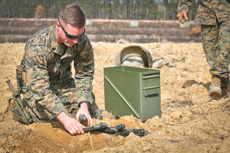 A Marine prepares C-4 charges around an inert munition at Townsend Bombing Range. The Explosive Ordnance Disposal Marines were called to the range to dispose of any munitions that still contained spotting rounds, a small explosive charge used to show pilots where the munition impacted. The Marine is with EOD, MCAS Beaufort/MAG-31