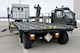 Senior Airman Ryan Hood, 25K Halvorsen Loader driver, looks on as Senior Airman Jacob Dietz, ramp operations journeyman, stands atop the K-Loader to direct the loading of an air transportable galley-lavatory in transit to a C-17 Globemaster III.