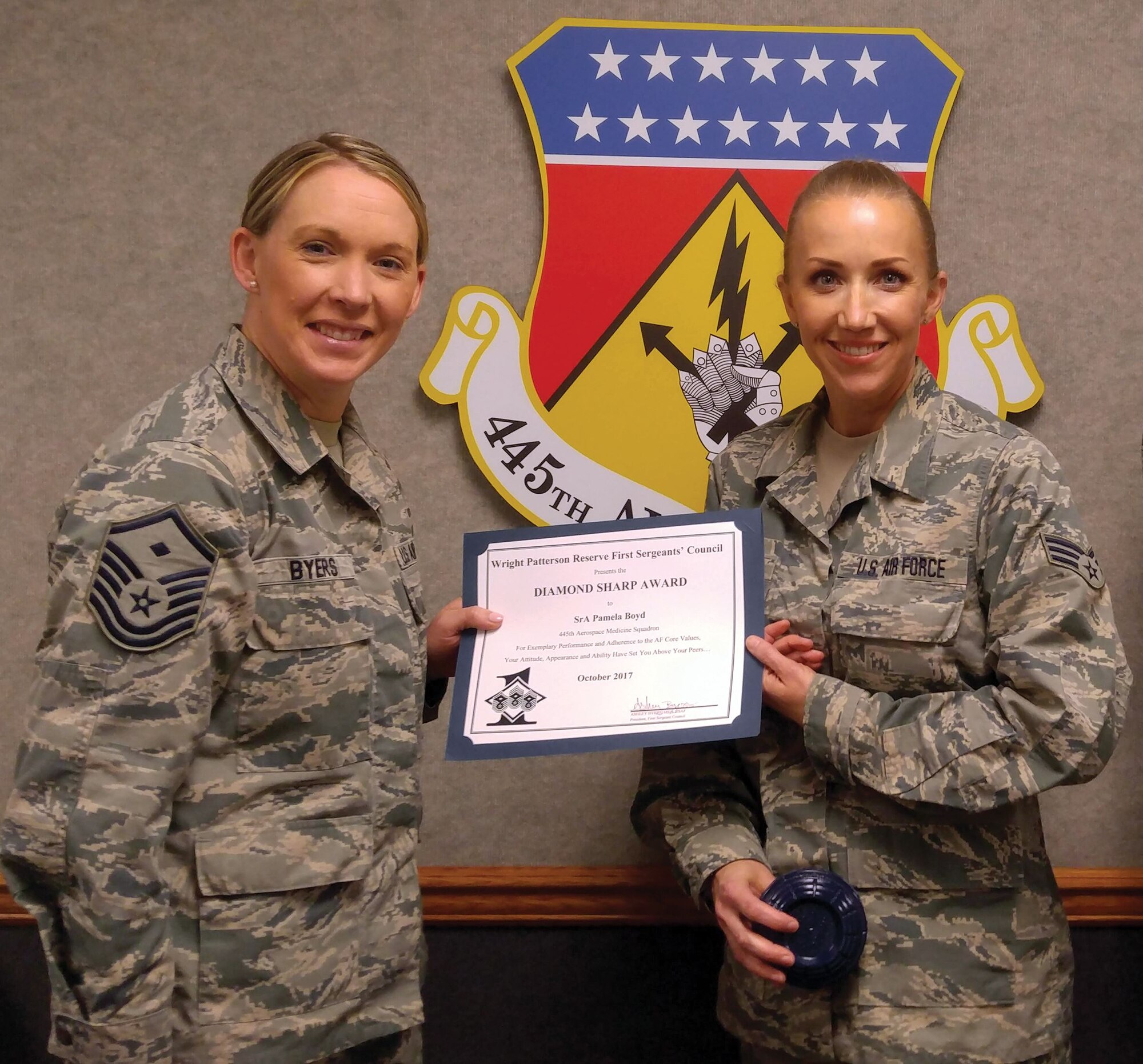 Master Sgt. Ashley Byers, 14th Intelligence Squadron first sergeant, presents the October 2017 Diamond Sharp Award to Senior Airman Pamela Boyd, 445th Aerospace Medicine Squadron, during the January 6, 2018 unit training assembly.