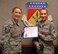 Master Sgt. Ashley Byers, 14th Intelligence Squadron first sergeant, presents the October 2017 Diamond Sharp Award to Senior Airman Pamela Boyd, 445th Aerospace Medicine Squadron, during the January 6, 2018 unit training assembly.