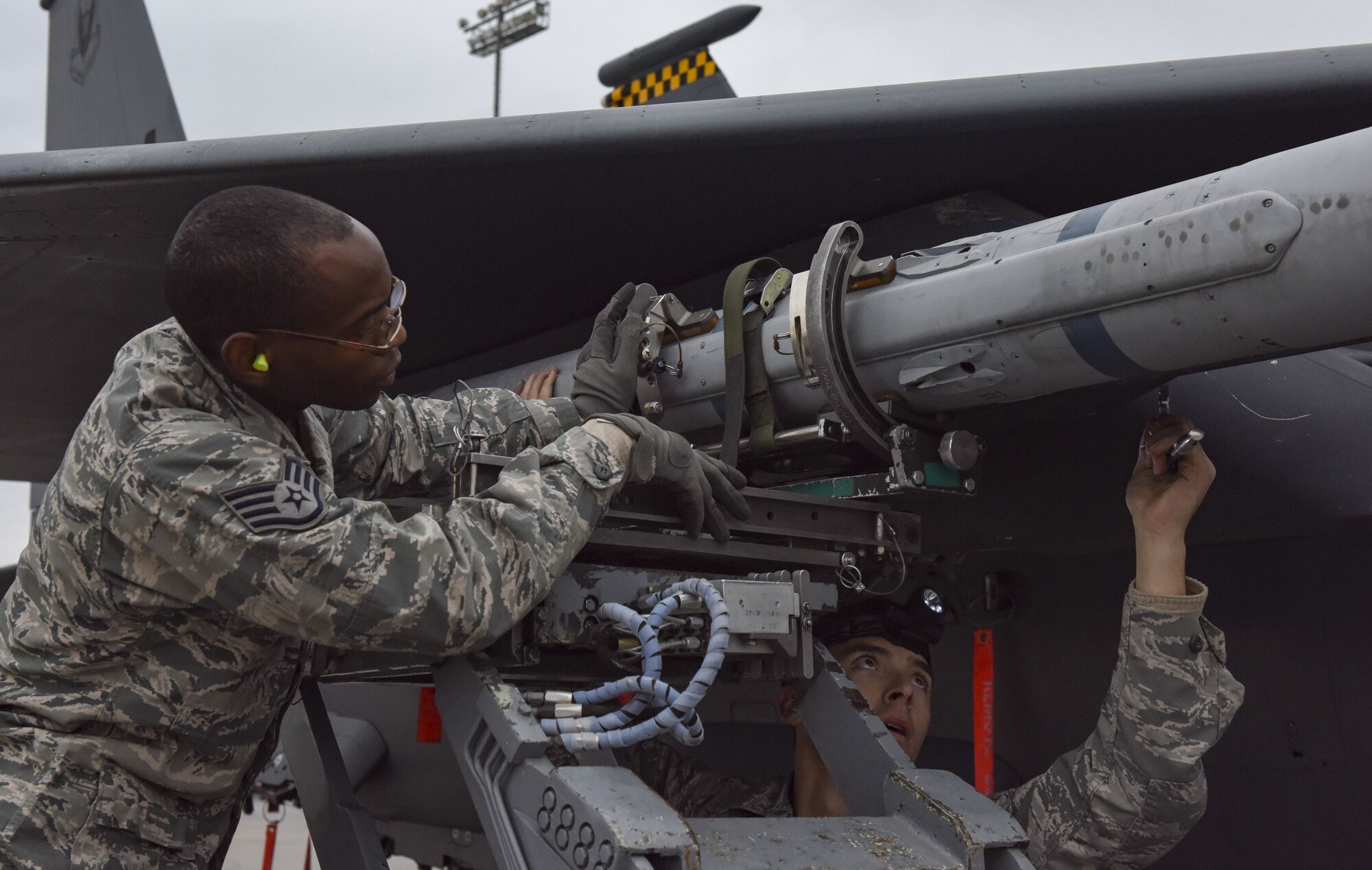 Staff Sgt. Mekai Stewart and Staff Sgt. Brett Rosales-Carr, both 57th Aircraft Maintenance Squadron load crew members, load an AIM-120 missile onto an F-15 Eagle during the load crew competition of the year at Nellis Air Force Base, Nev., Jan. 8, 2018. Load crew competitions challenge the teams’ capabilities to load munitions on aircraft in an accurate, safe and timely manner. (U.S. Air Force photo by Airman 1st Class Andrew D. Sarver)