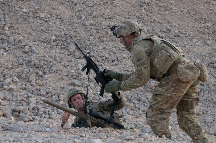Army Cpl. Jacob Kehler, a sniper team noncommissioned officer with Headquarters Company, 1st Battalion, 6th Infantry Regiment, 2nd Armored Brigade Combat Team, 1st Armored Division, trades weapons with Army Spc. Nathan Goodlet, a sniper with the unit, Jan 28. 2018, during exercise Inferno Creek 2018 near Thumrait, Oman.