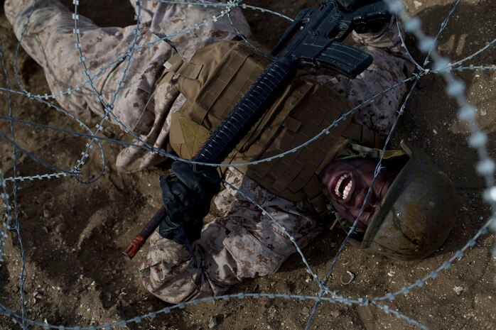 Recruits with Kilo Company, 3rd Recruit Training Battalion, crawl under barbed wire during a bayonet assault course at Marine Corps Recruit Depot San Diego, Jan. 30. The recruits were instructed to utilize their rifles to help shield them from the barbed wire as they crawled to the next portion of the course. Annually, more than 17,000 males recruited from the Western Recruiting Region are trained at MCRD San Diego. Kilo Company is scheduled to graduate March 16.
(Photo by: Cpl. Erick J. ClarosVillalta)