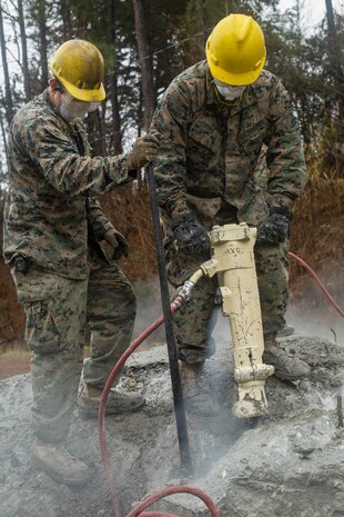 Marine Corps Pfc. Nathaniel Ford, right, a combat engineer with 8th Engineer Support Battalion, 2nd Marine Logistics Group, demolishes concrete with a jackhammer aboard Camp Lejeune, N.C., Jan. 29, 2018. The land was cleared to make room to facilitate more advanced future structures being constructed. (U.S. Marine Corps photo by Lance Cpl. Tyler W. Stewart)