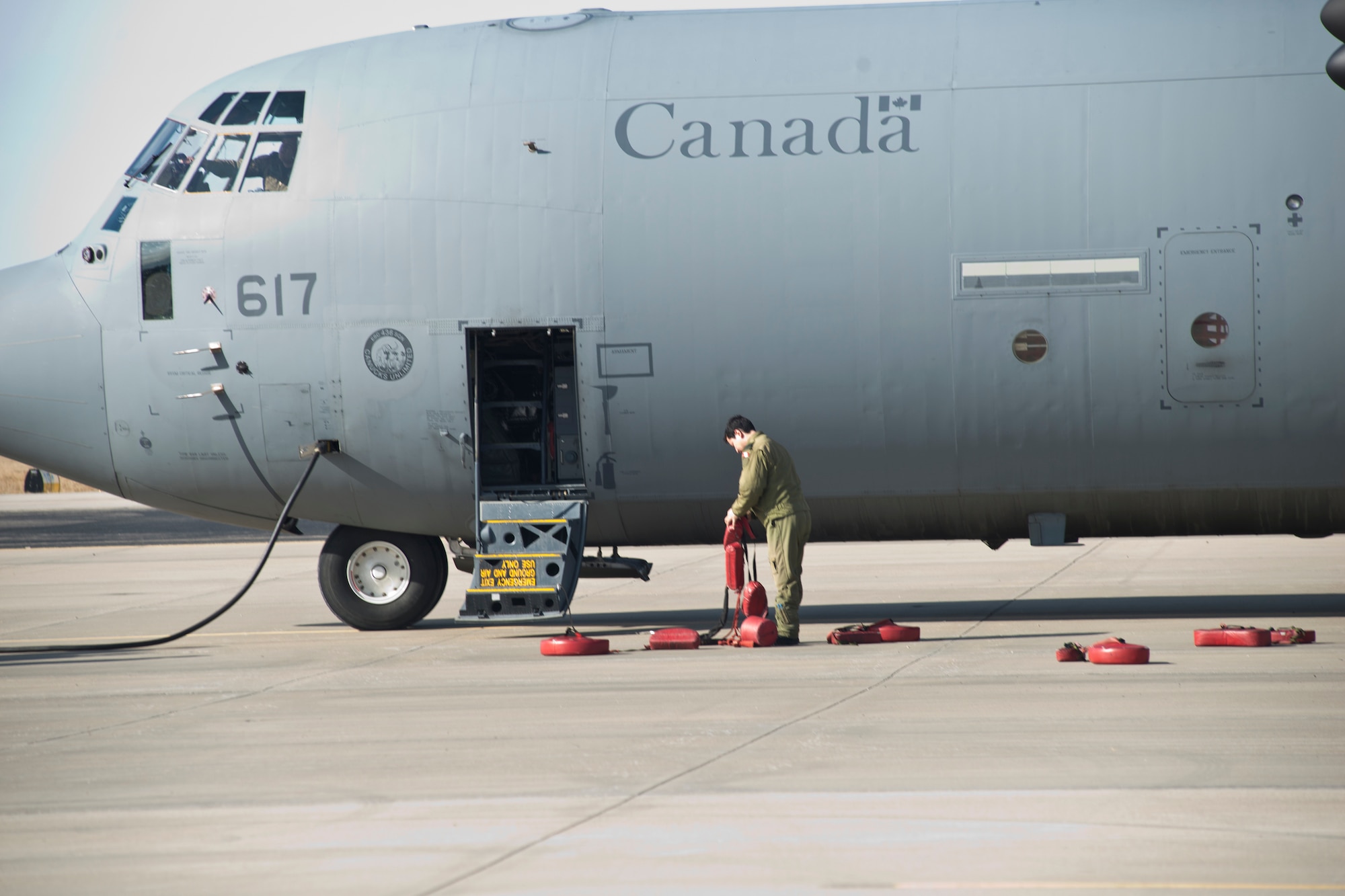 A Royal Canadian Air Force member chocks the wheels of his CC-130J aircraft at Rosecrans Memorial Airport, St. Joesph, Mo. February 1, 2018 after a training flight for the Treaty on Open Skies. Personnel from the United States, Canada, United Kingdom, France and the Czech Republic participated in the flight designed to promote international cooperation and transparency. (U.S. Air National Guard photo/Tech. Sgt. John Hillier)