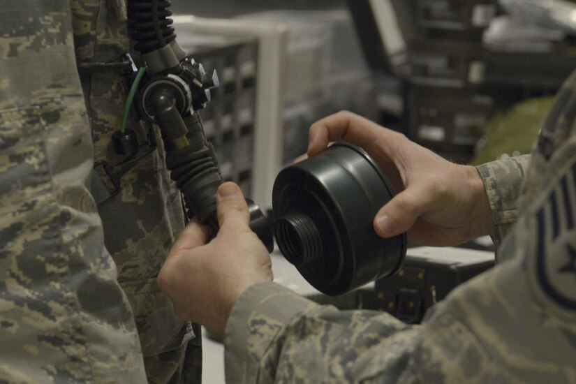 U.S. Air Force Staff Sgt. Brian Spears, 437th OSS aircrew flight equipment lead trainer, demonstrates the proper procedure for attaching a filter cartridge to an oxygen tube during a training session Feb. 1, 2018.