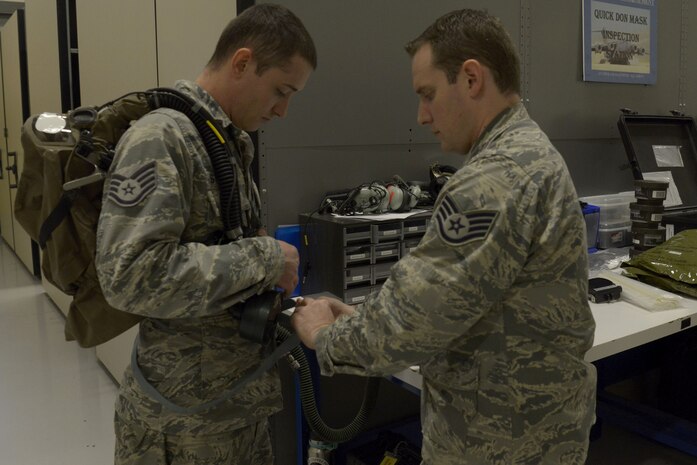 U.S. Air Force Staff Sgt. Brian Spears, right, 437th OSS aircrew flight equipment lead trainer, shows U.S. Air Force Staff Sgt. Justin Stepleton, left, 437th Operations Support Squadron NCO in charge of the AFE flotation section, proper procedures for donning equipment Feb. 1, 2018.