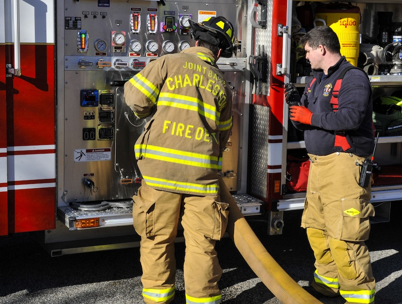 Senior Airman Michael Snipes, left, 628th Civil Engineer Squadron operator, handles the hose of a firetruck with Patrick Smith, right, 628th CES operator Jan. 26, 2018, at Joint Base Charleston – Weapons Station, S.C.