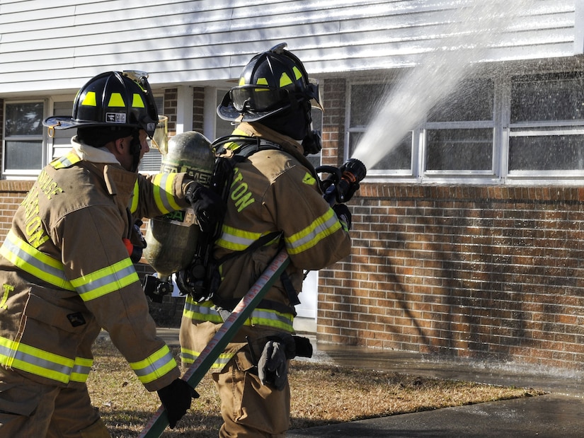 Josean Melendez, left, 628th Civil Engineer Squadron operator, supports Staff Sgt. Blaine West, right, 628th CES operator while he operates a firetruck hose Jan. 26, 2018, at Joint Base Charleston – Weapons Station, S.C.