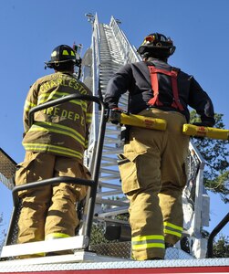 Senior Airman Michael Snipes, left, 628th Civil Engineer Squadron operator, operates the ladder of a firetruck with Patrick Smith, right, 628th CES operator Jan. 26, 2018, at Joint Base Charleston – Weapons Station, S.C.