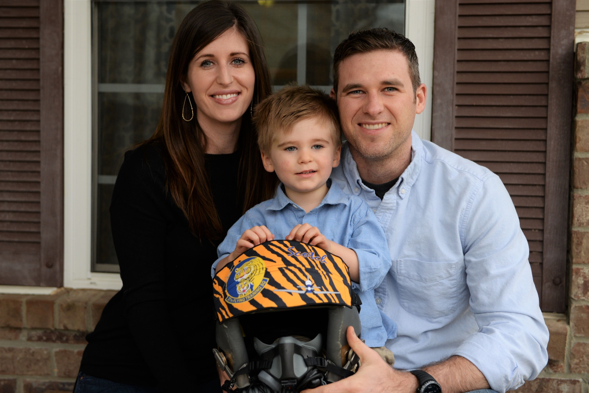 Capt. Hunter Barnhill, a 37th Flying Training Squadron instructor pilot, sits with his wife, Crystal, and their 3-year-old son, Nowlan, Jan 28, 2018, on Columbus Air Force Base, Mississippi. Many friends and families from Columbus AFB gave artwork and memorabilia from the 37th FTS to show their support for their family through his brain surgery and recovery process. (U.S. Air Force photo by Airman 1st Class Keith Holcomb)