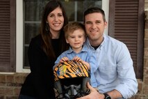 Capt. Hunter Barnhill, a 37th Flying Training Squadron instructor pilot, sits with his wife, Crystal, and their 3-year-old son, Nowlan, Jan 28, 2018, on Columbus Air Force Base, Mississippi. Many friends and families from Columbus AFB gave artwork and memorabilia from the 37th FTS to show their support for their family through his brain surgery and recovery process. (U.S. Air Force photo by Airman 1st Class Keith Holcomb)