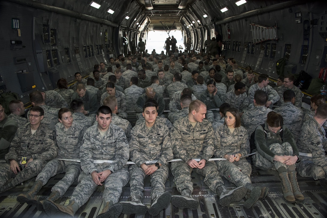 Airmen sit in an aircraft during an event.