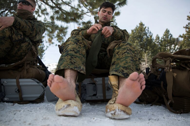 Cpl. Daniel Aldana, a distribution specialist with Combat Logistics Regiment 25, 2nd Marine Logistics Group changes his socks during a tactical pause on a hike during cold weather training at Marine Corps Mountain Warfare Training Center in Bridgeport, Calif., Jan. 26, 2018. Approximately 90 Marines participated in the week-long event where they learned survival skills, how to traverse mountainous terrain and cold weather weapons maintenance. The training will prepare the Marines for joint-force training exercise Artic Edge in northern Alaska, which will expose Marines to the peninsula’s weather extremes. (U.S. Marine Corps photo by Sgt. Brianna Gaudi)
