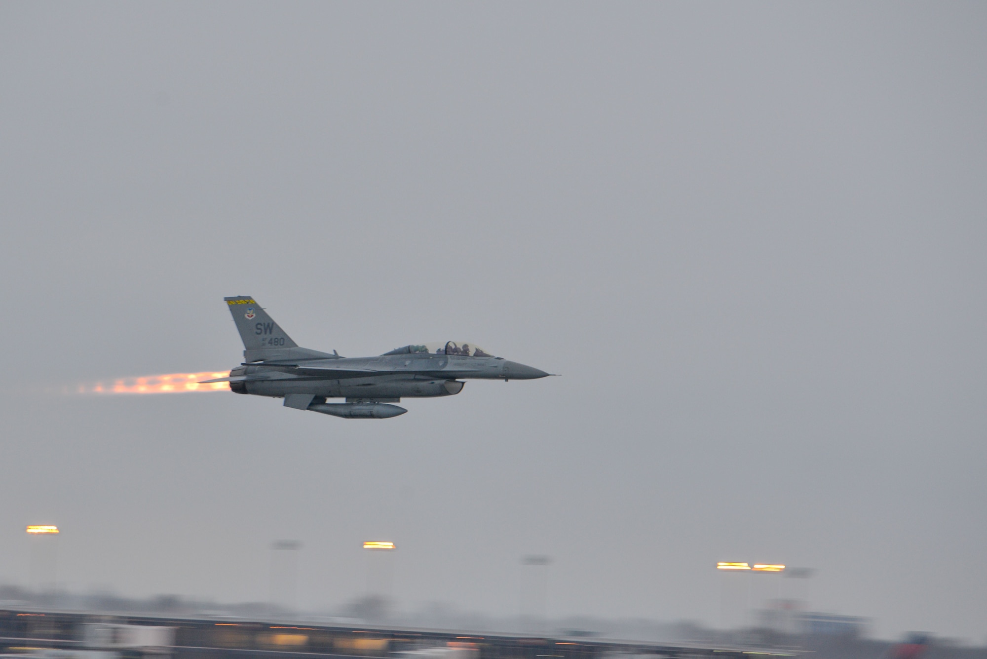 An F-16 with actress Elizabeth Banks in the passenger seat and Maj. John Waters piloting is takes to the skies with full afterburn at the Minneapolis-St. Paul Air Reserve Station, Minn., Feb 3, 2018.  The F-16 is part of the Air Force Heritage Flight flyover for Super Bowl LII.(U.S. Air Force photo by Master Sgt. Eric Amidon)