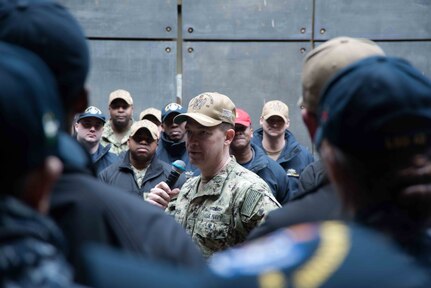 Rear Adm. Brad Cooper, commander of Amphibious Force 7th Fleet, speaks to Sailors aboard the amphibious dock landing ship USS Germantown (LSD 42) during an all hands call.