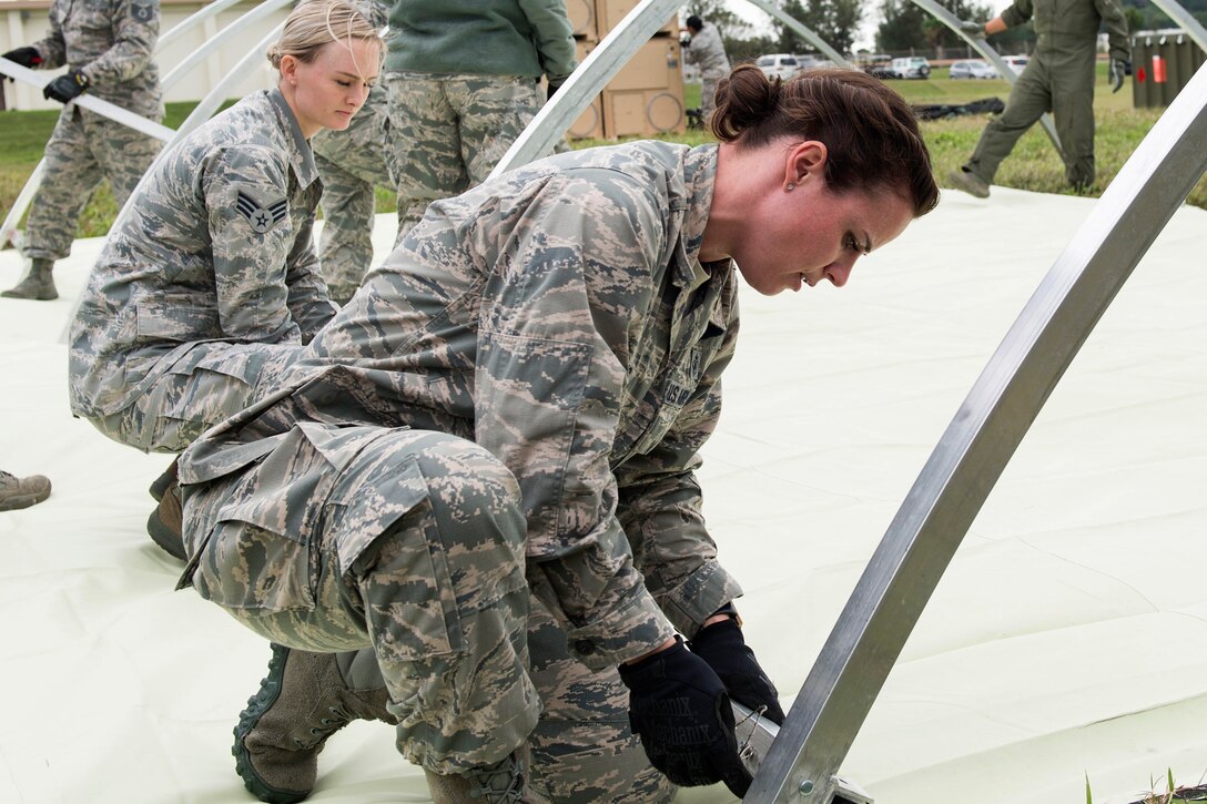 Airmen assemble the structural framing for a tent.