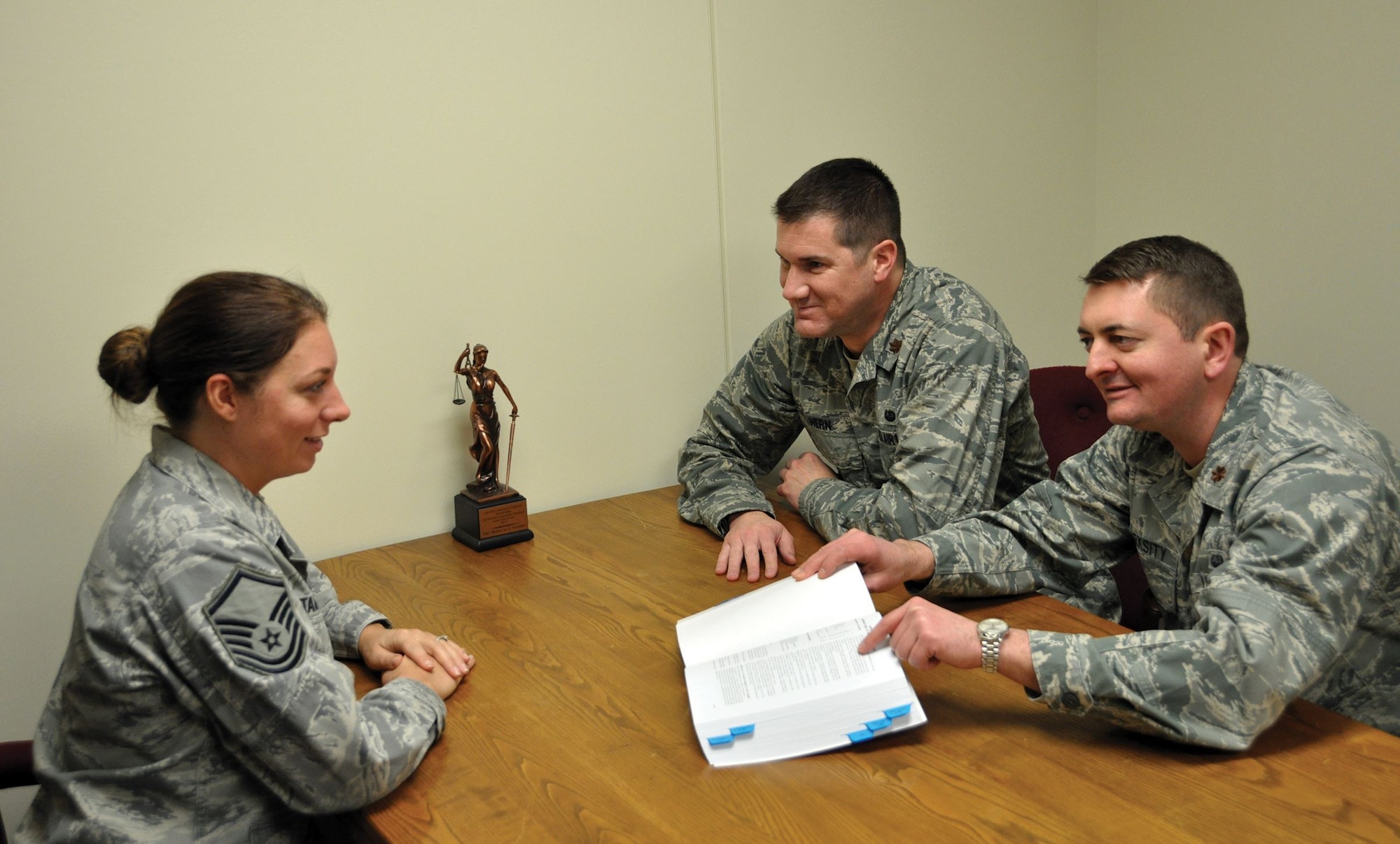 Master Sgt. Rebeccah Stammen, law office superintendent, reviews military legal guidance with Majs. (right) Drew Marksity, adverse actions chief, and Kyle Hern, deputy staff judge advocate, Jan. 7, 2018