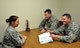 Master Sgt. Rebeccah Stammen, law office superintendent, reviews military legal guidance with Majs. (right) Drew Marksity, adverse actions chief, and Kyle Hern, deputy staff judge advocate, Jan. 7, 2018