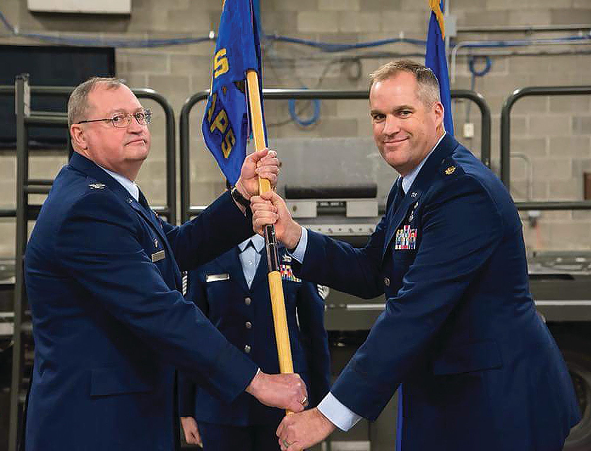Col. Bryan Runion, 445th Mission Support Group commander, passes the guidon to Maj. David Borden, incoming 87th Aerial Port Squadron commander, during the January 6, 2018 change-of command ceremony