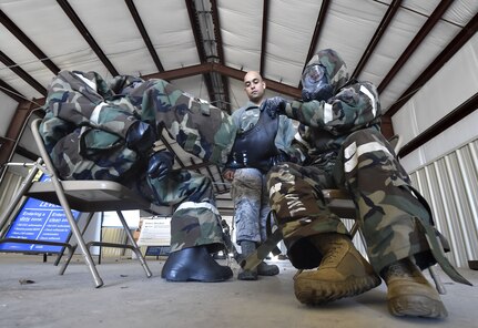 Senior Airman Paul Chavis III, center, 628th Civil Engineer Squadron, familiarizes Airmen of the 621st Contingency Response Wing, Joint Base McGuire-Dix-Lakehurst, New Jersey, with chemical, biological, radiological and nuclear defense techniques during Exercise Crescent Moon Jan. 30, at Joint Base Charleston’s North Auxiliary Airfield near Orangeburg, South Carolina.