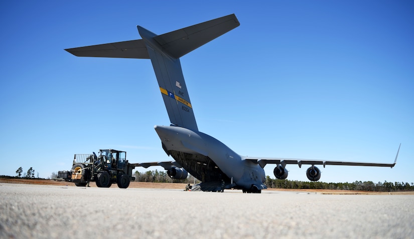 Airmen load cargo onto a C-17 Globemaster III, from the 14th Airlift Squadron, during a contingency response exercise at Joint Base Charleston’s North Auxiliary Airfield, near Orangeburg, South Carolina, Jan. 29, 2018.