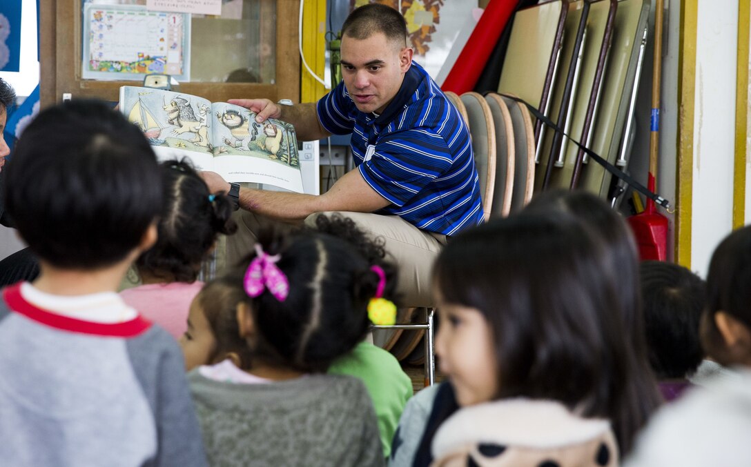 U.S. Marine Corps Cpl. Darren Broughton reads Where the Wild Things Are to children during a visit to Namisato Preschool in Okinawa, Japan, Jan. 30, 2018. Marines visited the school as a community relations event that helps the children learn basic English. Broughton, an Odessa, Texas native, is a team leader with Kilo Company, 3rd Battalion, 3rd Marine Regiment, 3rd Marine Division.. Marines continue fostering relations with the local population and building bonds with allies.