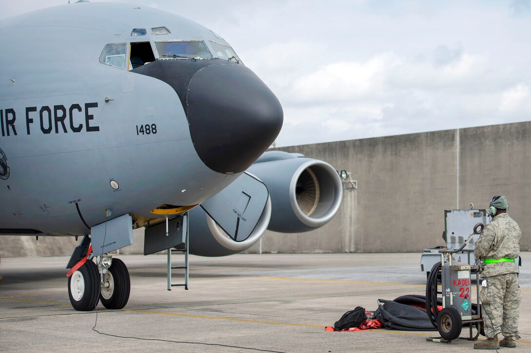 An airman stands in front of a KC-135R Stratotanker