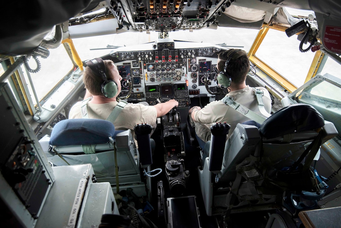 Two airmen sit in the cockpit of a KC-135R Stratotanker.