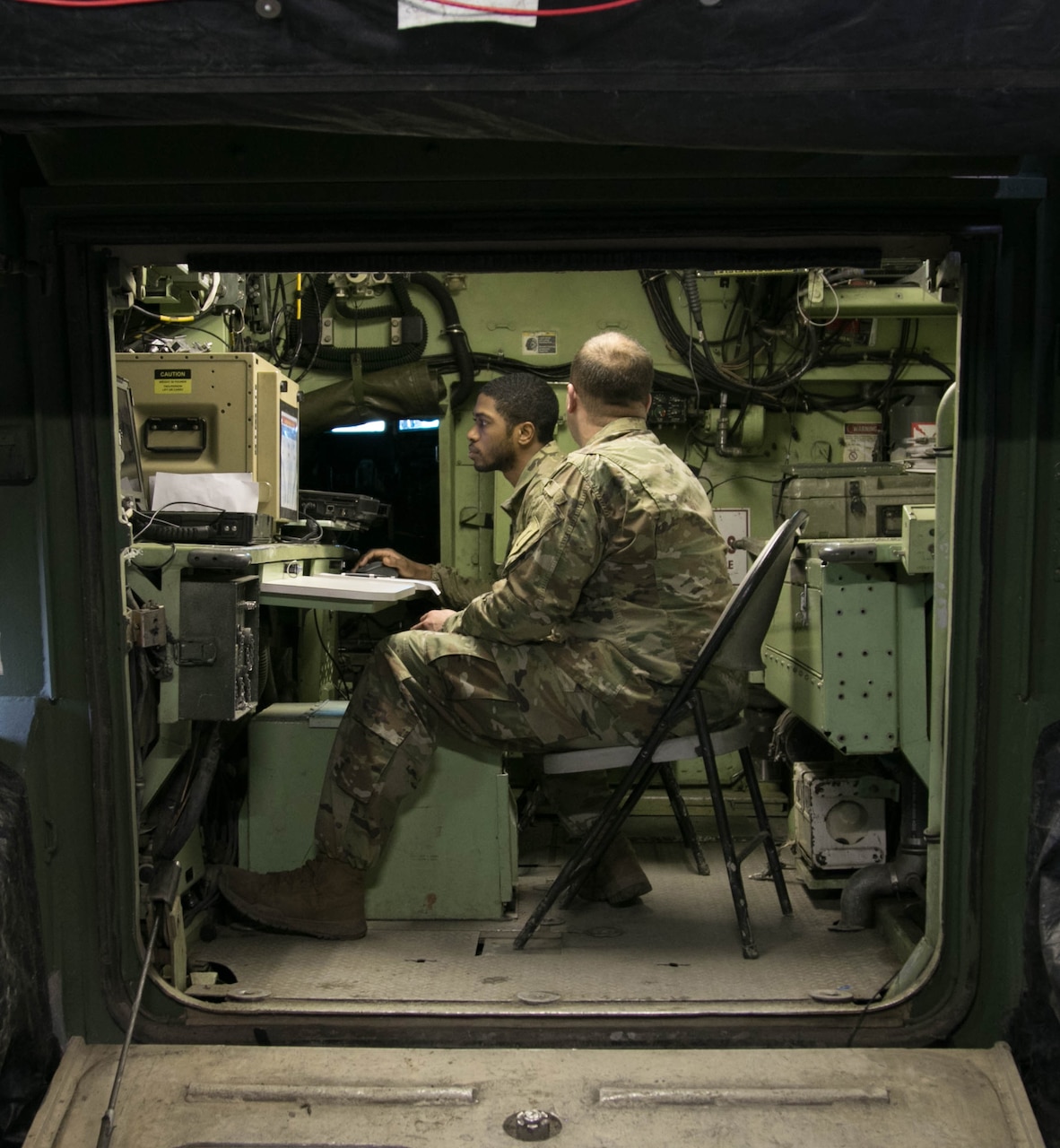 Army Sgt. Darryl Griffith, looking at a computer screen, tracks, manages and relays data to fire support assets from the fire direction center during a live-fire training exercise at Grafenwoehr Training Area, Germany, Feb. 2, 2018. Griffith is a fire support specialist assigned to 1st Battalion, 7th Field Artillery Regiment. Army photo by Staff Sgt. Sharon Matthias
