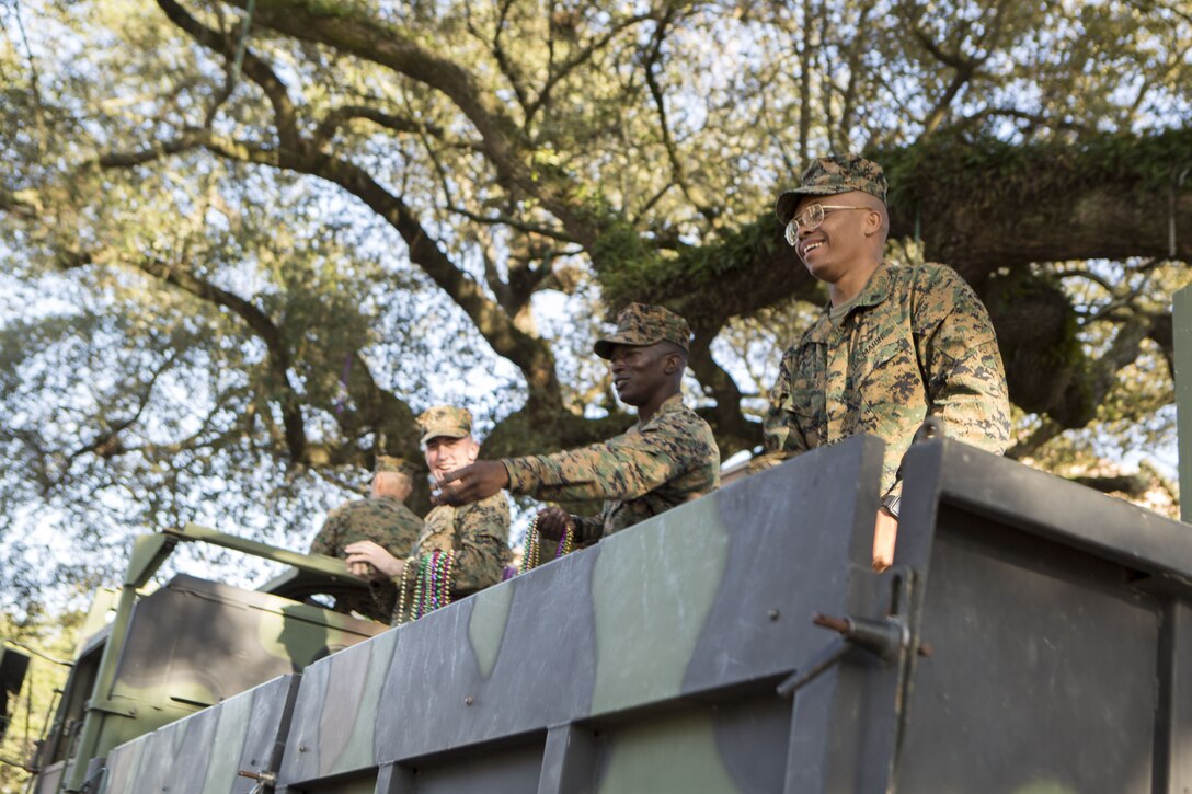 Marines with Marine Corps Support Facility New Orleans toss beads to  New Orleans parade goers during the Krewe of Alla Mardi Gras parade, Feb. 4, 2018. The Marines participated in the parade to support the local community and celebrate the Mardi Gras season.