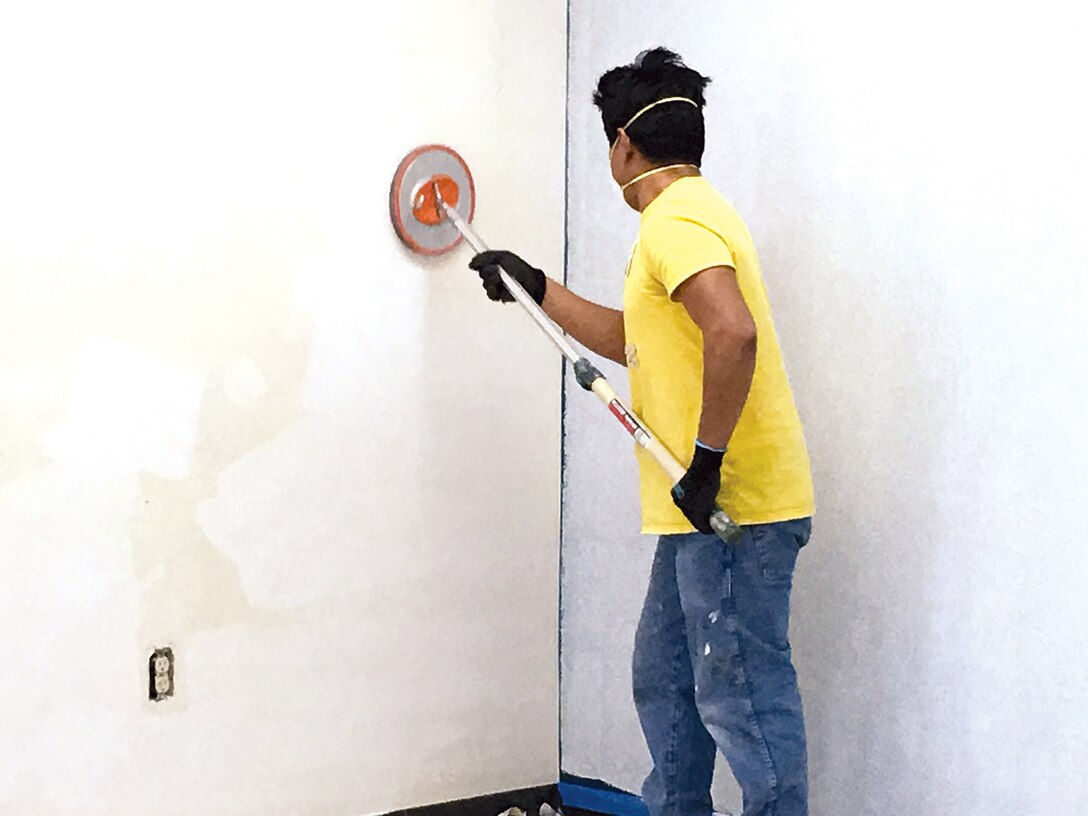 A worker prepares the walls in a room at the Barber Physical Activity Center (BPAC) to prepare them for a fresh coat of paint as part of the facilities' refresh which is currently underway.