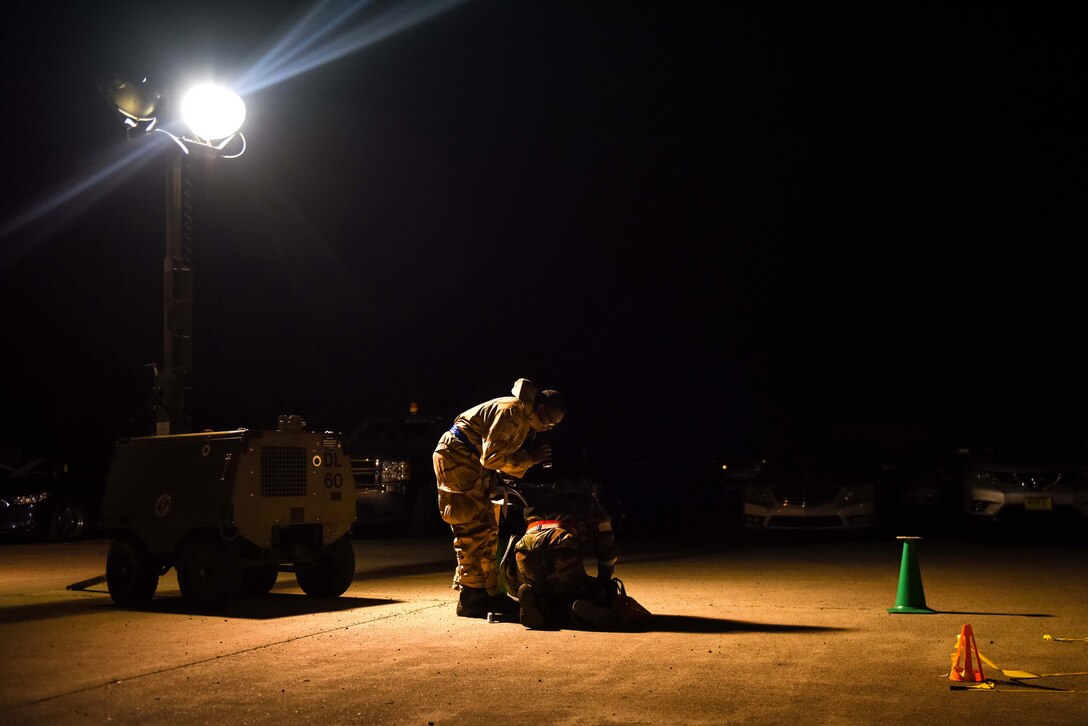 Airmen check equipment outside at night.
