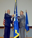 Maj. Gen. Bradley D. Spacy, commander of the Air Force Installation and Mission Support Center, passes the unit flag to Edwin H. Oshiba