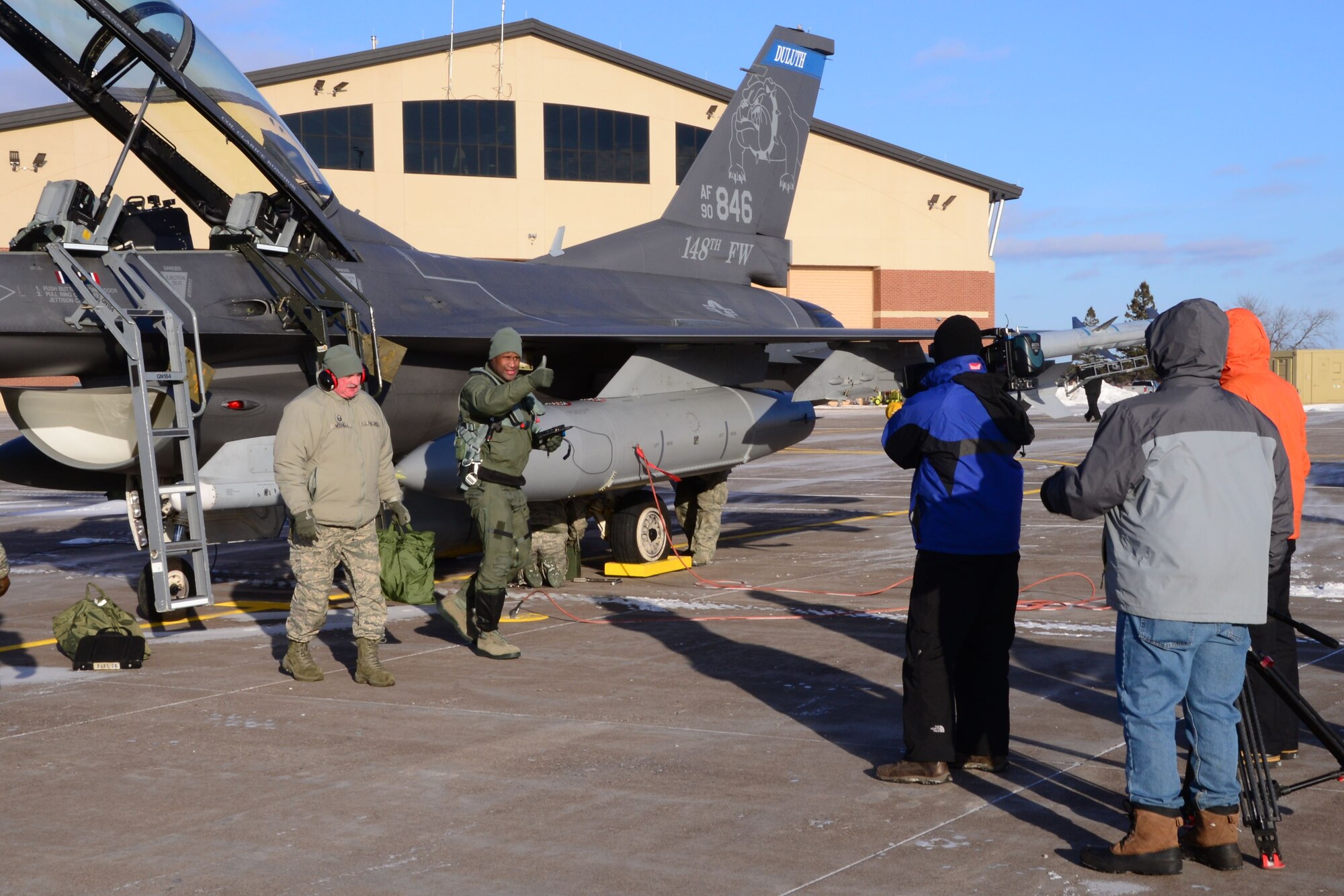 Ron Mott, a nationally-syndicated television broadcaster, gives a thumbs up to his camera crew following his mission familiarization flight with the Minnesota Air National Guard’s 148th Fighter Wing, Duluth, MN. The flight showcased NORAD's air-defense mission and included intercept operations with a Civil Air Patrol aircraft and an inflight refueling with a Wisconsin Air National Guard KC-135 from the 128th Air Refueling Wing. NORAD, along with their interagency partners -- the FAA, Department of Homeland Security, and Customs and Border Patrol -- provided the air defense shield for this year's Super Bowl being held in Minneapolis, MN.  (Air Force photo by Maj. Andrew Scott)