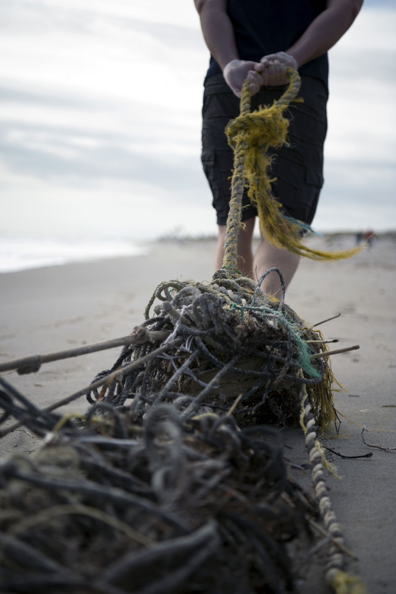 A volunteer pulls tangled rope and net debris to a disposal area at Patrick Air Force Base’s Beach House on Feb. 3, 2018. Patrick’s Airman Leadership School class held a volunteer beach clean-up event in an effort to make Space Coast beaches a more community-friendly environment. (U.S. Air Force photo by Airman Zoe Thacker)