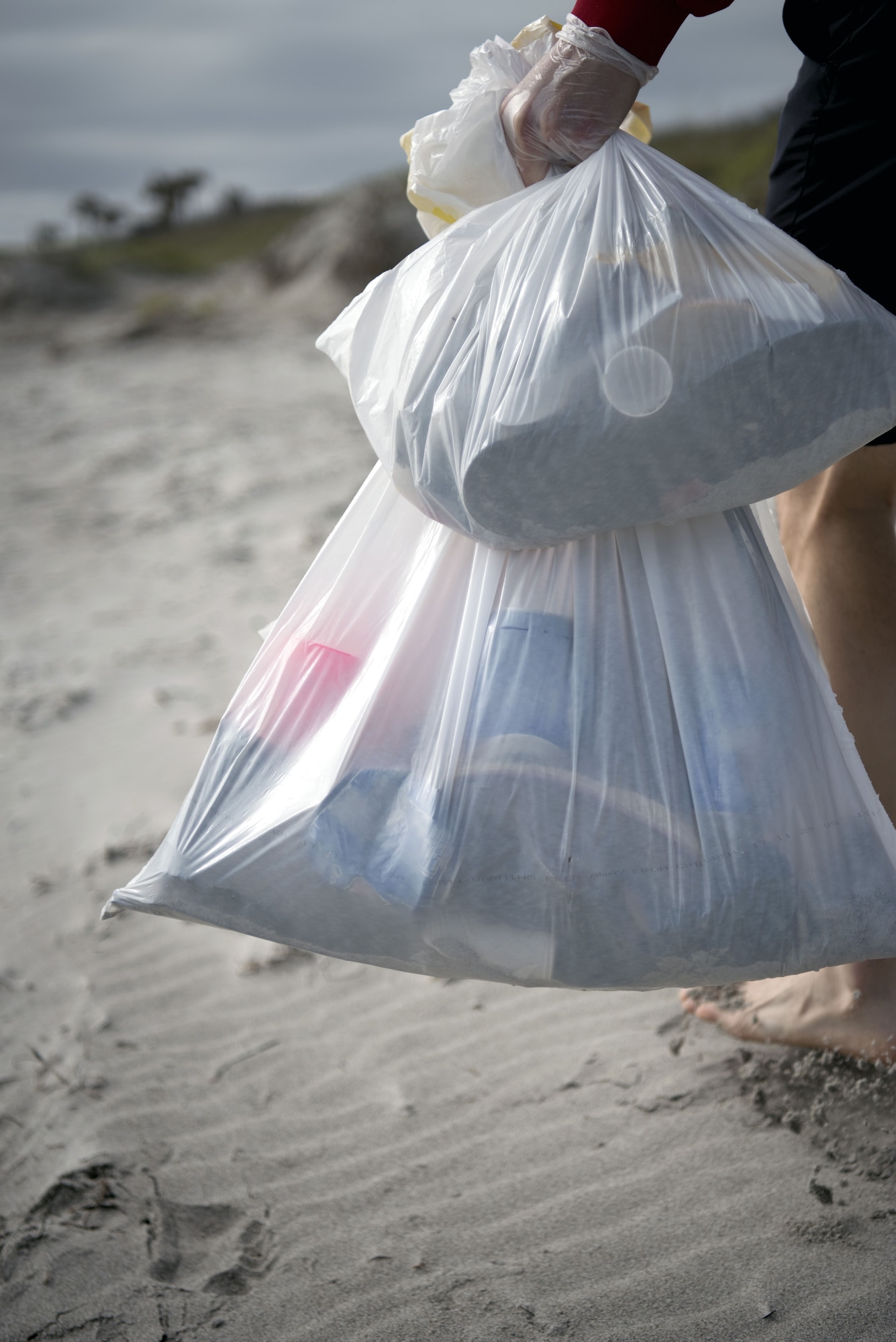 A volunteer carries bags of debris to the designated disposal area at Patrick Air Force Base’s Beach House on Feb. 3, 2018. Patrick’s Airman Leadership School class held a volunteer beach clean-up event in an effort to make Space Coast beaches a more community-friendly environment. (U.S. Air Force photo by Airman Zoe Thacker)