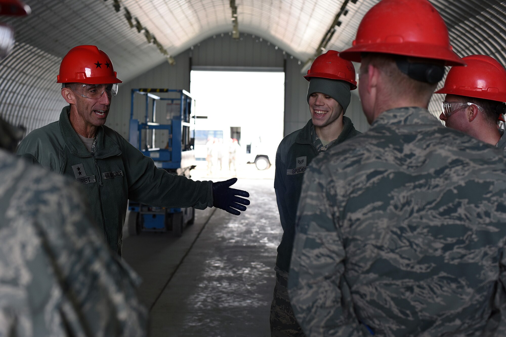 U.S. Air Force Maj. Gen. Scott J. Zobrist, left, 9th Air Force commander, speaks with Staff Sgt. Nicholas Spudich and members of the 819th Rapid Engineer Deployable Heavy Operational Repair Squadron Engineers (RED HORSE) storage K-Span troop training project team at Malmstrom Air Force Base, Mont., Jan. 25, 2018, inside a K-Span storage facility the Airmen are building. Once complete, the structure will house RED HORSE equipment. RED HORSE Airmen capitalize on construction opportunities at home to maintain proficiency for their overseas missions. (U.S. Air Force photo by Kiersten McCutchan)